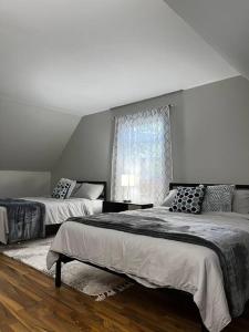 1 Schlafzimmer mit 2 Betten und einem Fenster in der Unterkunft Cozy cottage by the lake in Tobyhanna