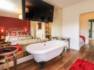 a large bathroom with a tub and a bed at Moor End Manor in Poulton le Fylde