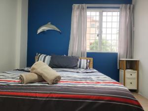 a bedroom with a bed with blue walls and a window at 3B2R Sanitise 6Pax Kota kemuning Shah Alam in Shah Alam