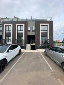 twee auto's geparkeerd op een parkeerplaats voor een gebouw bij Lovely one bedroom condo with free parking in Niagara Falls