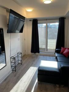 een woonkamer met een bank en een flatscreen-tv bij Lovely one bedroom condo with free parking in Niagara Falls