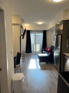 een woonkamer met een bank en een koelkast bij Lovely one bedroom condo with free parking in Niagara Falls