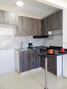 a kitchen with wooden cabinets and a sink at Confortable Apartamento in Barranquilla