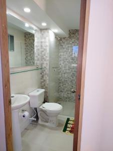 La salle de bains est pourvue de toilettes, d'un lavabo et d'une douche. dans l'établissement Confortable Apartamento, à Barranquilla