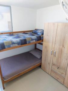 a bedroom with a bunk bed and a wooden cabinet at Confortable Apartamento in Barranquilla
