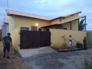 a group of people standing in front of a house at Casa amarela 1 quarto in Cabo Frio