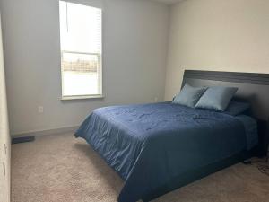 a bedroom with a blue bed with a window at Close to Disney. Big house with backyard in Orlando