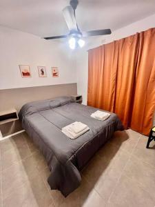 1 dormitorio con 1 cama y ventilador de techo en Lumiere apartments 5- Departamento en complejo residencial en El Challao