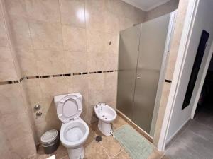 y baño con aseo, ducha y lavamanos. en Lumiere apartments 5- Departamento en complejo residencial en El Challao