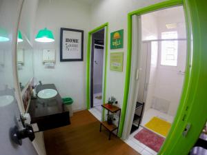 a green bathroom with a sink and a shower at Vila Rock Hostel - próximo Allianz Parque, Vila Madalena, Av Paulista, Hospital das Clínicas INCOR FMUSP in São Paulo