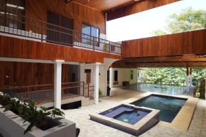 une maison avec une piscine au milieu dans l'établissement Hotel Ribera La Paz, à Piedades Norte