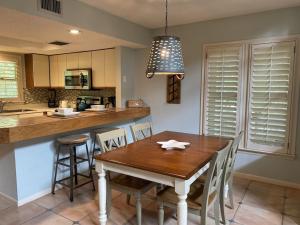 a kitchen with a wooden table and a dining room at Gated Gulf Front Condo in Hidden Dunes Beach & Tennis Resort in Destin