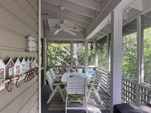 a screened porch with a table and chairs on it at Gated Gulf Front Condo in Hidden Dunes Beach & Tennis Resort in Destin