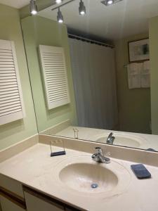 a bathroom with a sink and a large mirror at Gated Gulf Front Condo in Hidden Dunes Beach & Tennis Resort in Destin