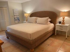 a bedroom with a large bed with a rattan headboard at Gated Gulf Front Condo in Hidden Dunes Beach & Tennis Resort in Destin