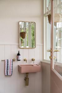 baño con lavabo rosa y espejo en Coltrane House -Luxury Getaway, en Mount Gambier