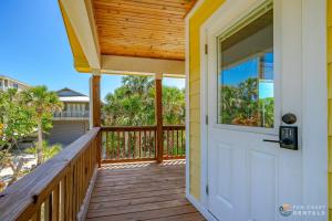 uma porta para um alpendre com vista para a praia em Lovely Guesthouse Loft with Balcony and Hammock STEPS from the Beach! em New Smyrna Beach