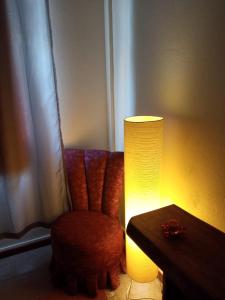 uma lâmpada sentada ao lado de uma cadeira ao lado de uma mesa em Fonte da Serra em Teresópolis