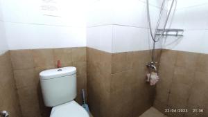 e bagno con servizi igienici bianchi e doccia. di Green Pramuka Apartment 2BR a Giacarta