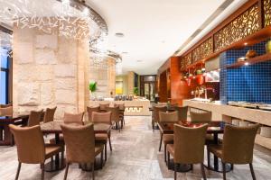 a restaurant with tables and chairs and a bar at The Yun Resort QingYuan in Qingyuan