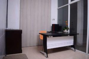 un bureau avec un bureau et une chaise dans la chambre dans l'établissement MOJOKERTO GUESTHOUSE, à Mojokerto