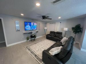 uma sala de estar com um sofá e uma televisão de ecrã plano em Family-Friendly DIsney Getaway em Kissimmee