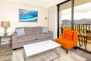 a living room with a couch and a chair at Panoramic Mountain View Condo with Free Parking! in Honolulu