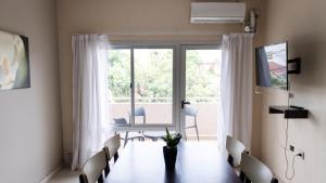 Un comedor con mesa y sillas y una ventana. en Luxury Apart, en Villa María