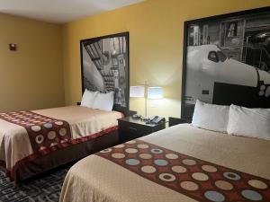 a hotel room with two beds and a picture on the wall at Super 8 by Wyndham Pasadena in Pasadena
