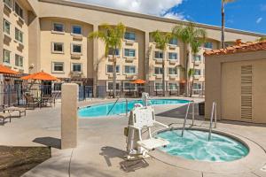 a swimming pool with a hotel in the background at Holiday Inn Express Colton, an IHG Hotel in Colton