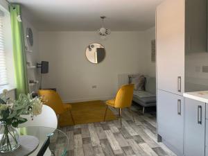 uma sala de estar com cadeiras amarelas e uma mesa em Peterborough City Center One Bed apartment With Free Private Parking em Peterborough