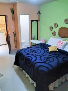 a bedroom with a large bed with a blue blanket at COMFY furnished private apartment.Netflix/internet in Chimaltenango
