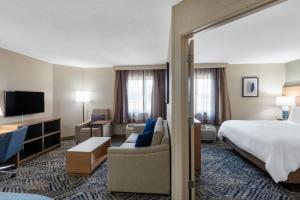 a hotel room with a bed and a tv at Candlewood Suites Chesapeake-Suffolk by IHG in Chesapeake