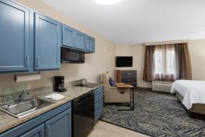 a hotel room with a kitchen and a bed at Candlewood Suites Chesapeake-Suffolk by IHG in Chesapeake