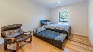 sala de estar con cama y silla en Holiday unit on Thompson Ave, Cowes, en Cowes