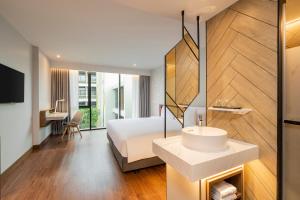 a hotel room with a bed and a sink at Centara Life Hotel Bangkok Phra Nakhon in Bangkok