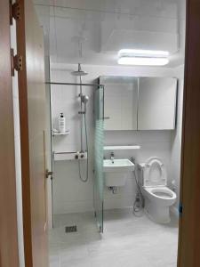 a bathroom with a shower and a toilet and a sink at Lakestone&Hotel Sokcho in Sokcho