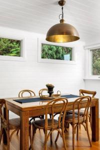 a dining room with a wooden table and chairs at Quarry Hill Cottage, 1 minute walk into Berrima. in Berrima