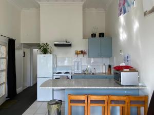 a kitchen with a white refrigerator and a counter at Beach house in Oriental Parade in Wellington