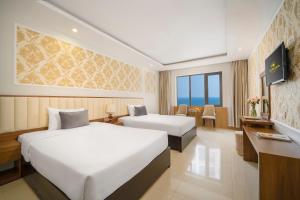 ein Hotelzimmer mit 2 Betten und einem Schreibtisch in der Unterkunft 7 Seven Sea Hotel in Đà Nẵng