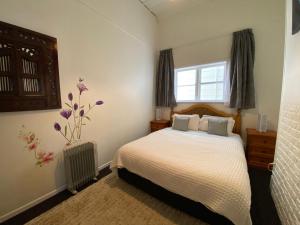 een slaapkamer met een bed en een raam bij Beach house in Oriental Parade in Wellington