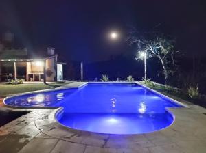 a blue swimming pool at night with a street light at Hostería La María in Rosario de la Frontera