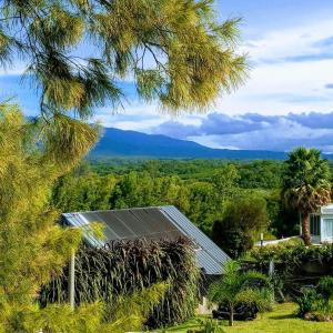 a house with a solar roof with mountains in the background at Hostería La María in Rosario de la Frontera