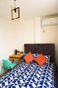 1 dormitorio con cama con almohadas de color naranja y escritorio en Casa Familiar con Piscina en Urbanización privada en Manta