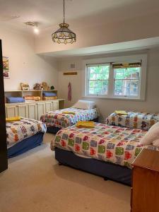 a bedroom with three beds and a window at York Cottage. A Country Retreat in Burradoo. in Burradoo