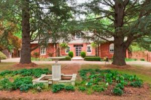 a park with a fountain in front of a house at York Cottage. A Country Retreat in Burradoo. in Burradoo