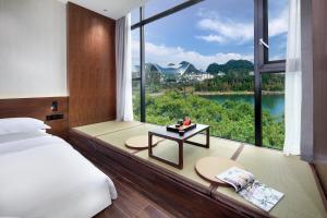 Postel nebo postele na pokoji v ubytování Riverside Wing Hotel Guilin