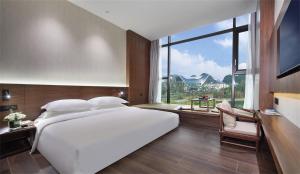 Postel nebo postele na pokoji v ubytování Riverside Wing Hotel Guilin