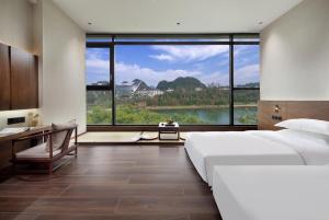 Postel nebo postele na pokoji v ubytování Riverside Wing Hotel Guilin