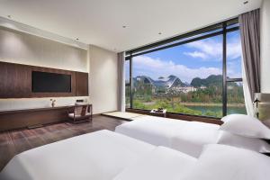 Postel nebo postele na pokoji v ubytování Riverside Wing Hotel Guilin